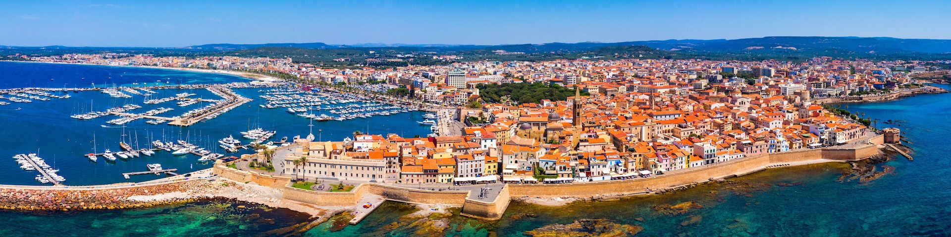 Aerial view over Alghero old town, cityscape Alghero view on a beautiful day with harbor and open sea in view. Alghero, Italy. Panoramic aerial view of Alghero, Sardinia, Italy.