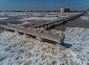 A pier extending into the ocean with waves crashing against it.