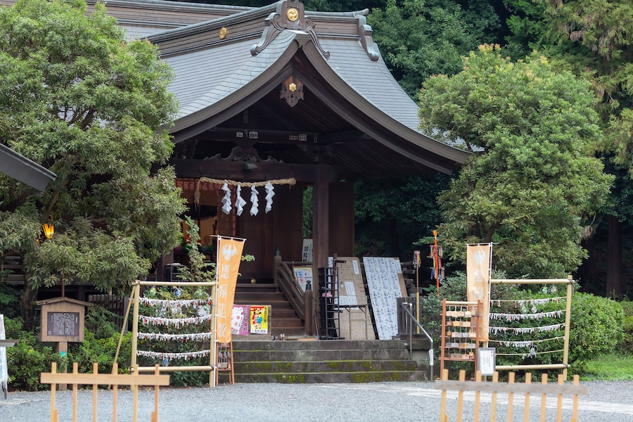 Een traditioneel Japans gebouw met een pannendak, omgeven door weelderig groen.