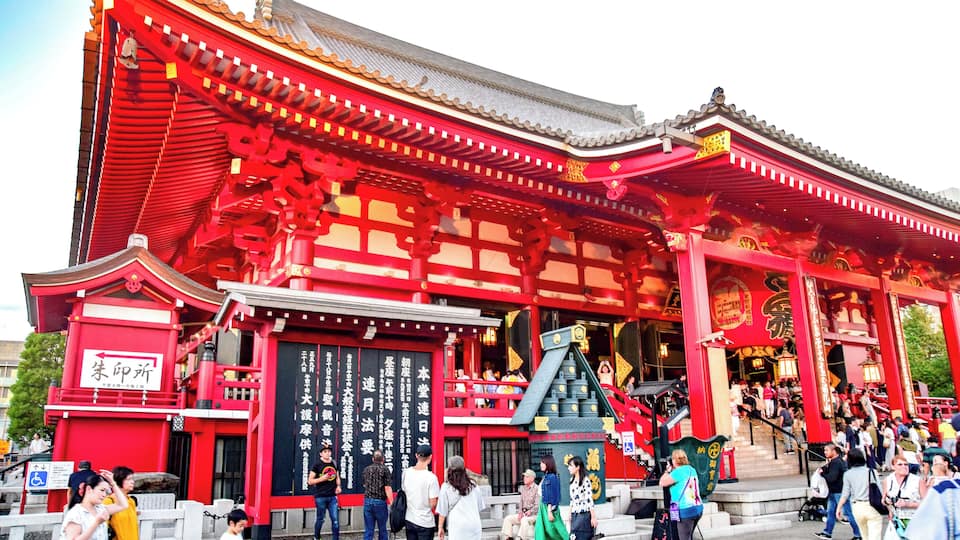Un bâtiment traditionnel de couleur rouge, doté d’une architecture riche et d’un grand escalier menant à l’entrée.
