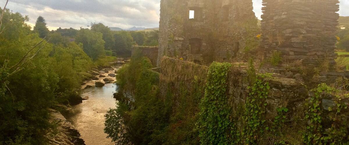 A river flowing through a landscape with ruins and greenery.