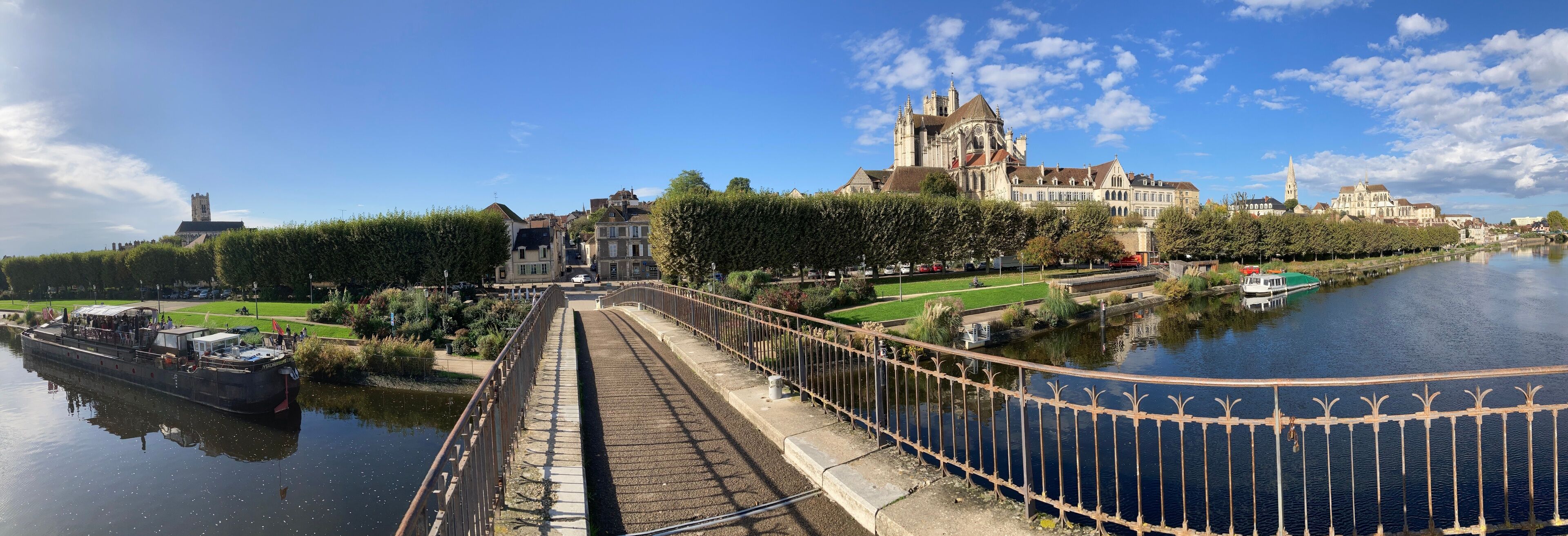 A river with a bridge, a large historic building, and a tower.