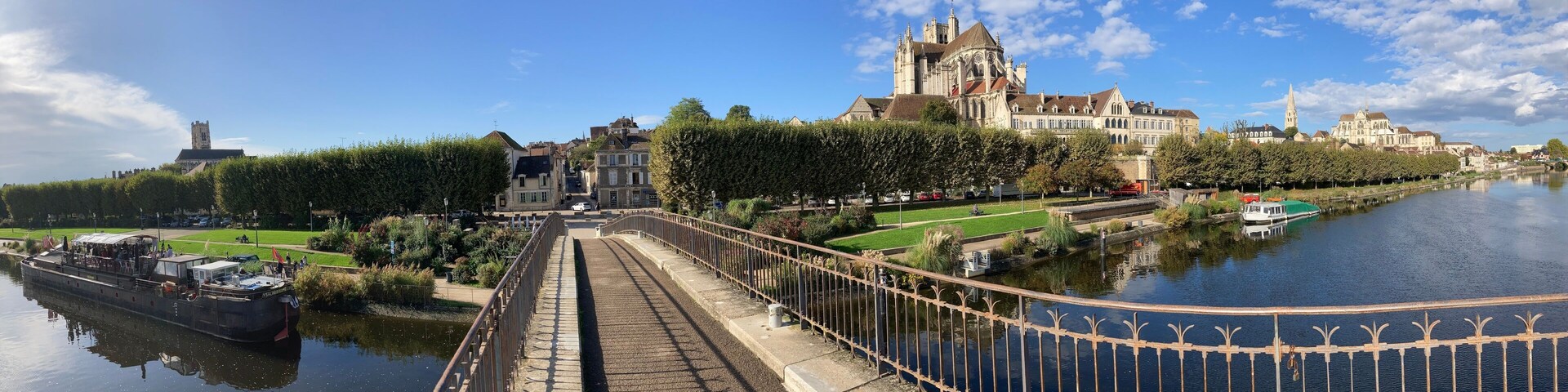 A river with a bridge, a large historic building, and a tower.