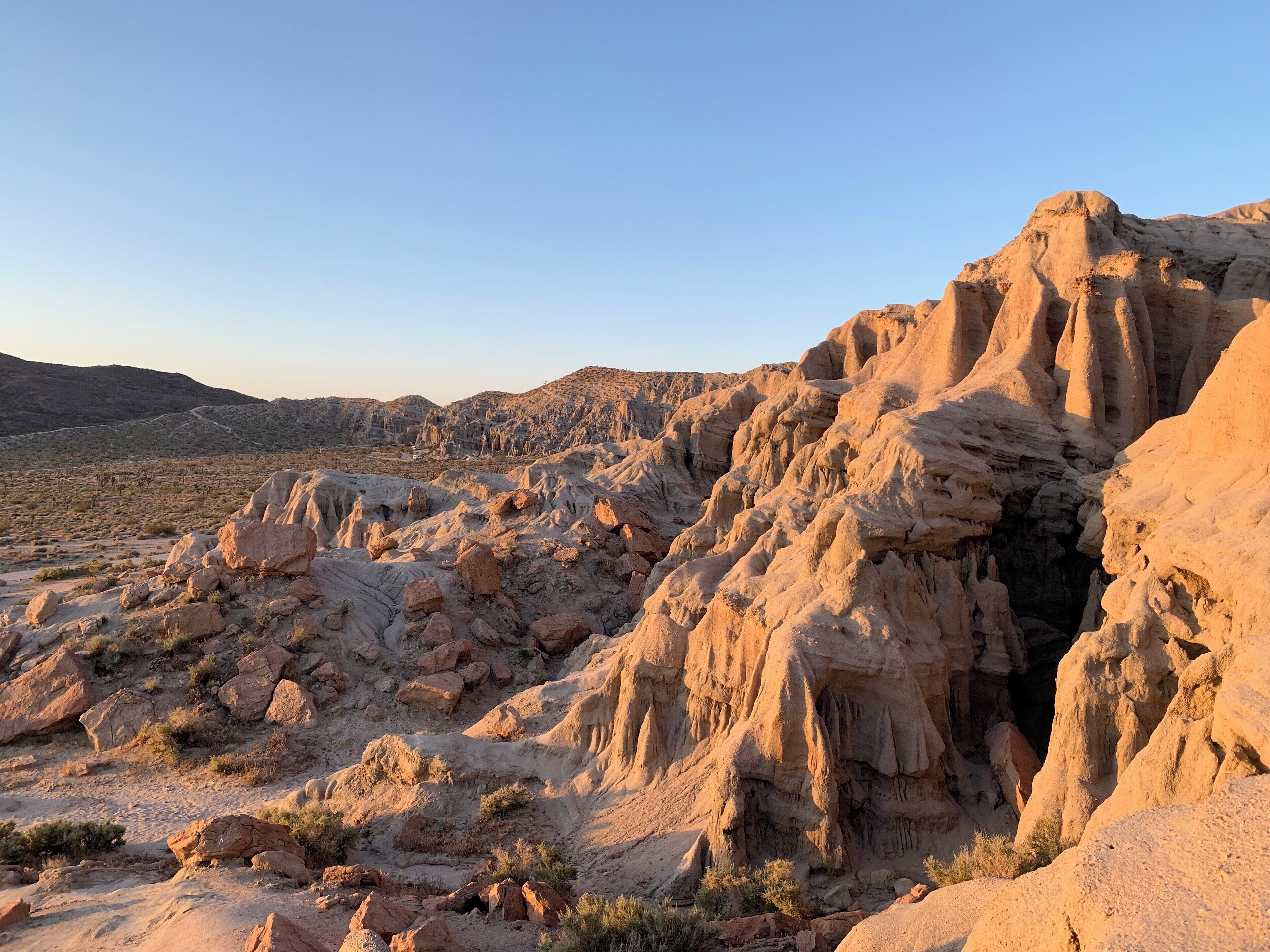 A desert landscape with prominent rock formations and sparse vegetation.