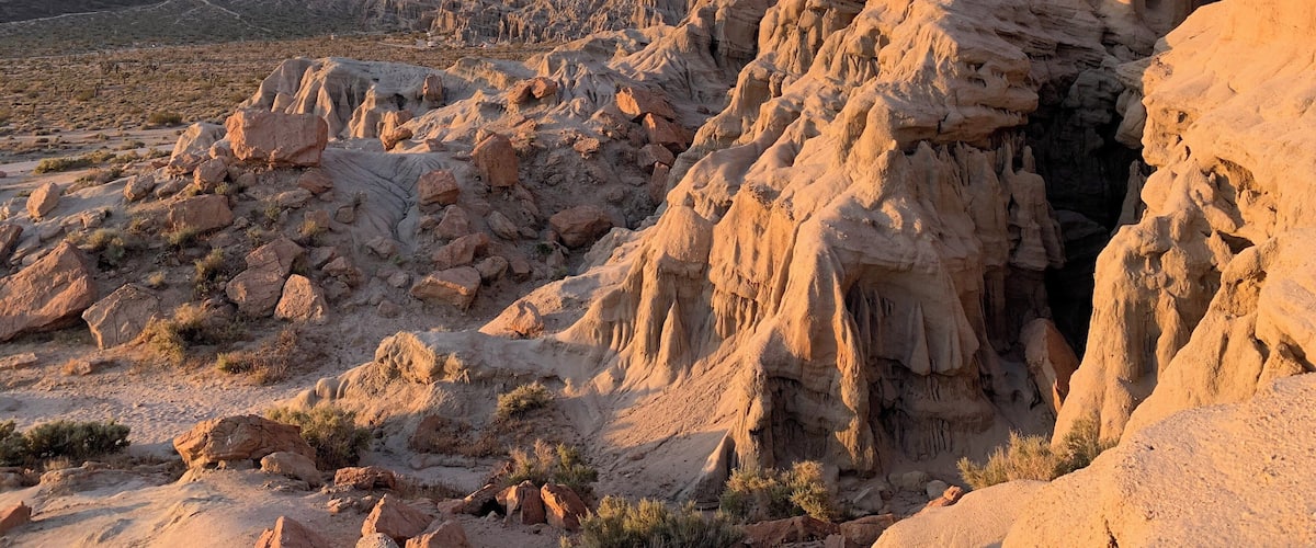 A desert landscape with prominent rock formations and sparse vegetation.