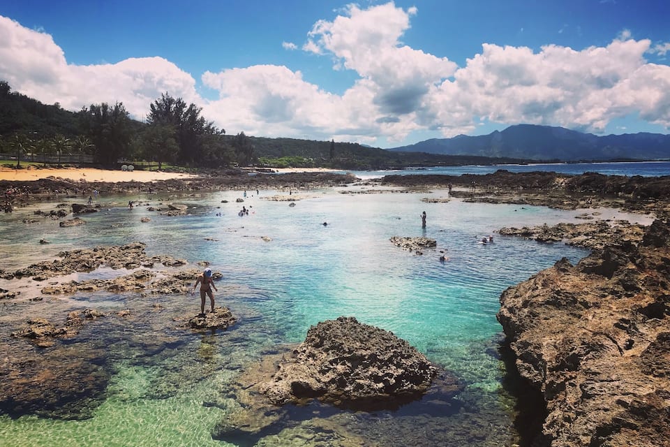 A clear coastal area with rocky formations and calm waters.