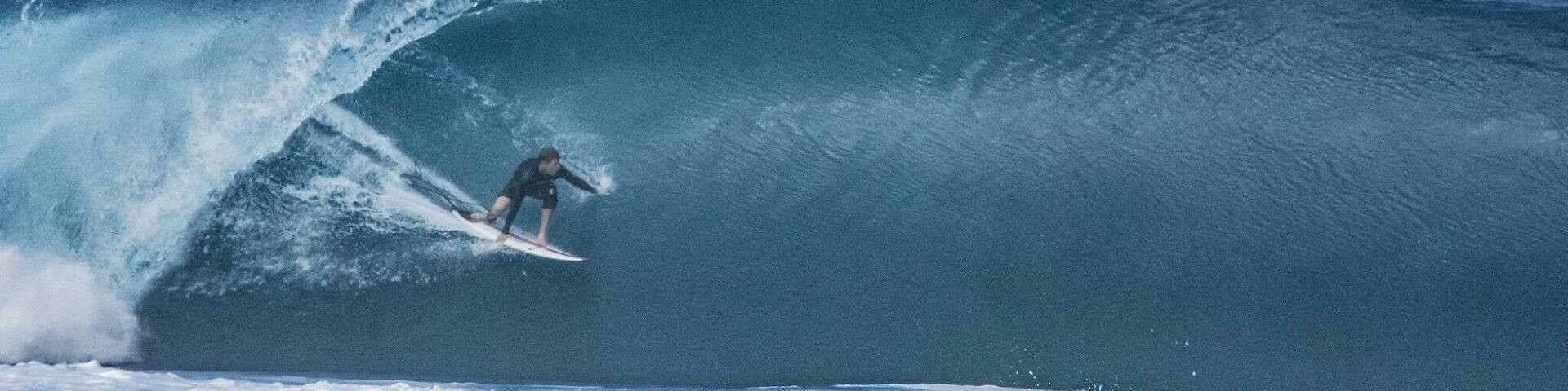 A surfer riding a large wave in the ocean.