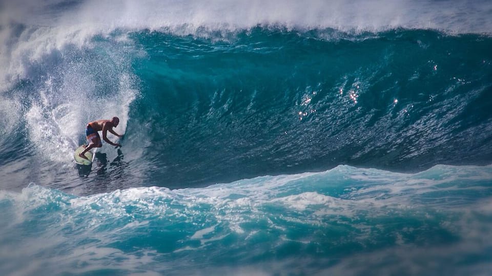 A surfer riding a large wave in the ocean.