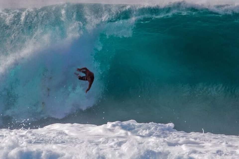 A surfer riding a large wave.