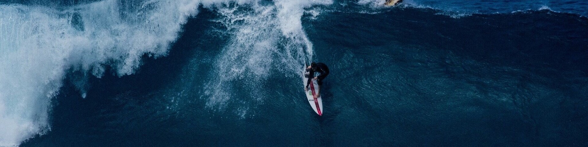 Un surfista montando una ola grande en el océano.