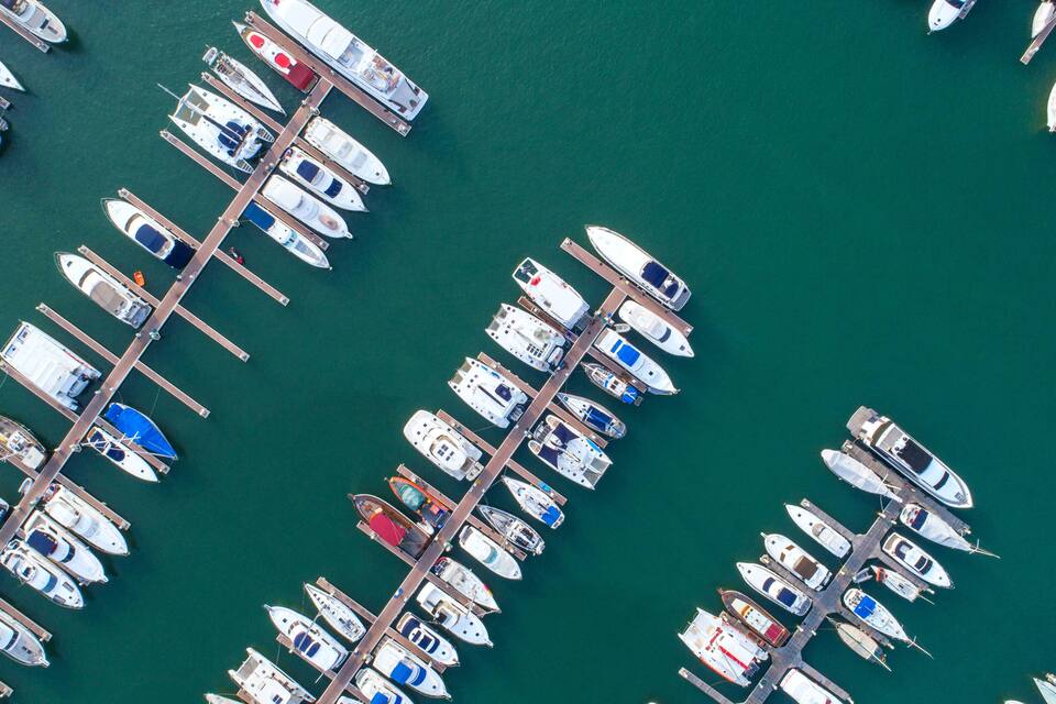 An aerial view of a marina with numerous boats docked at piers.