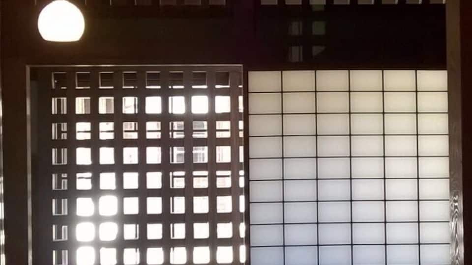 A traditional Japanese interior with tatami flooring, sliding doors, and shoji screens.