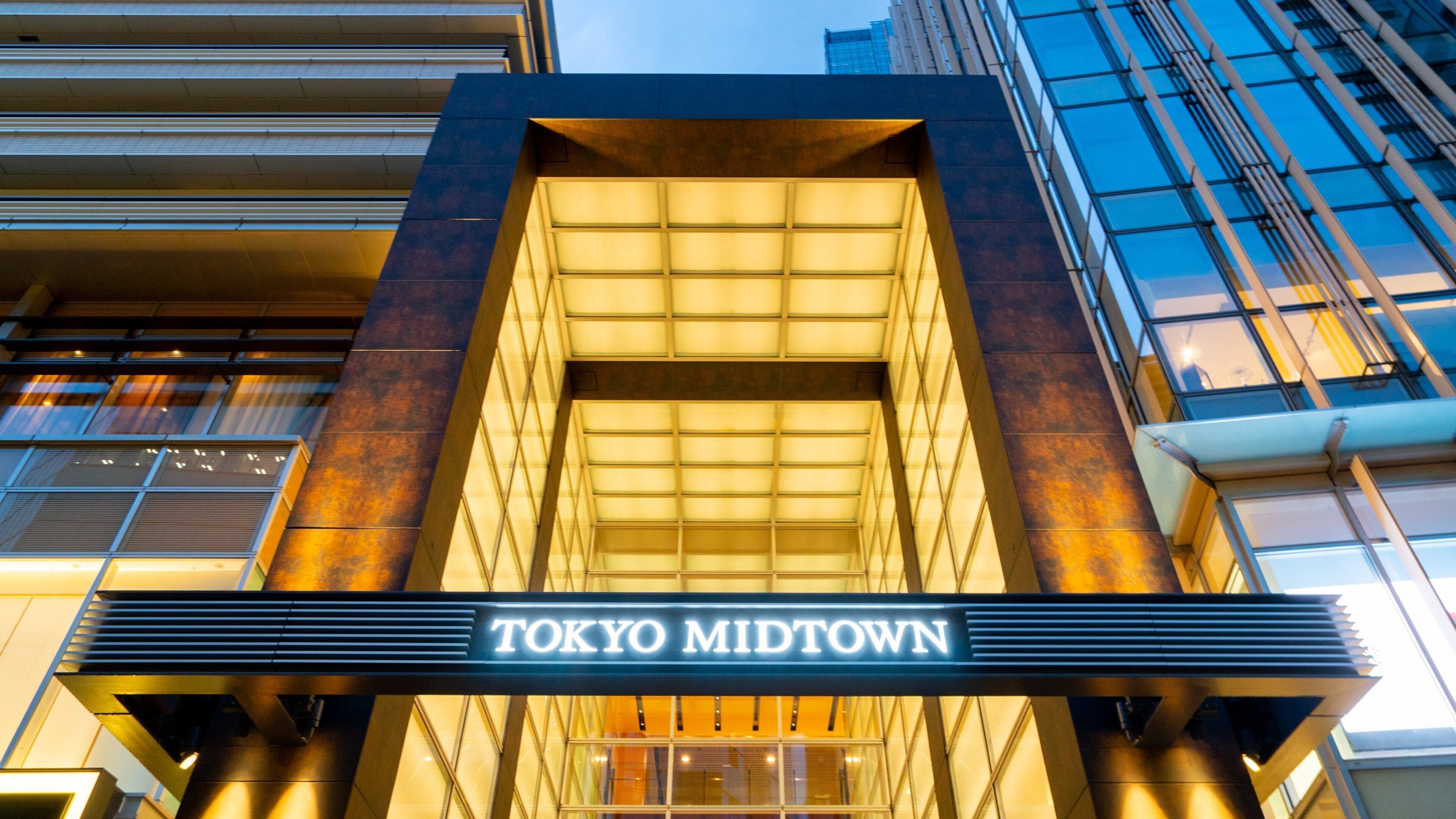 Fachada do edifício Tokyo Midtown com sinalização iluminada.