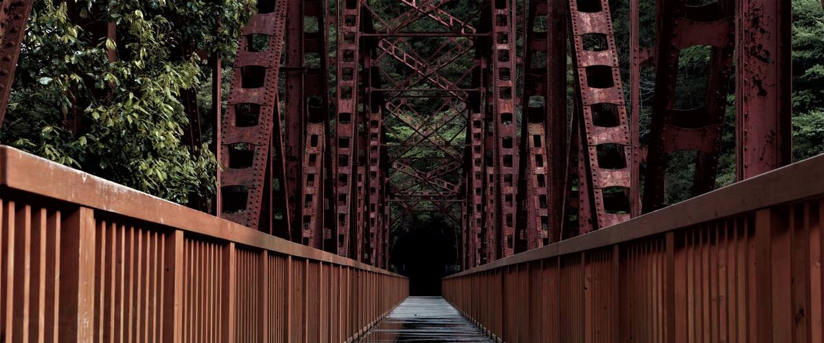 A railway bridge with a metal structure and wooden planks.