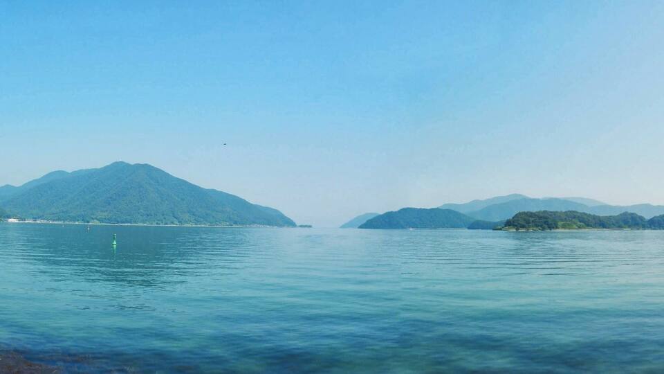 A calm lake with mountains in the background.
