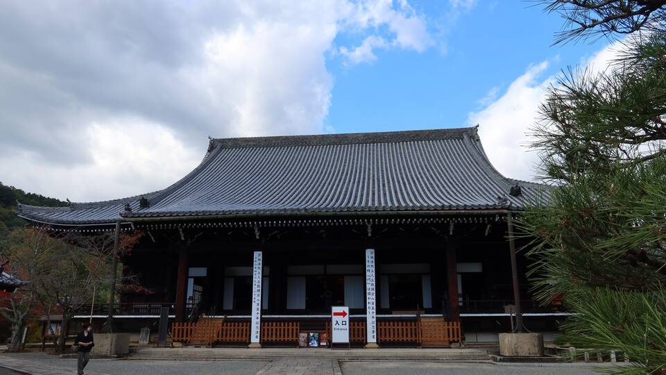 A traditional Japanese building with a curved roof and wooden pillars.