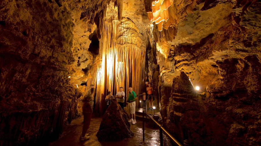 Een grot met stalactieten en stalagmieten, verlicht met kunstmatige verlichting.