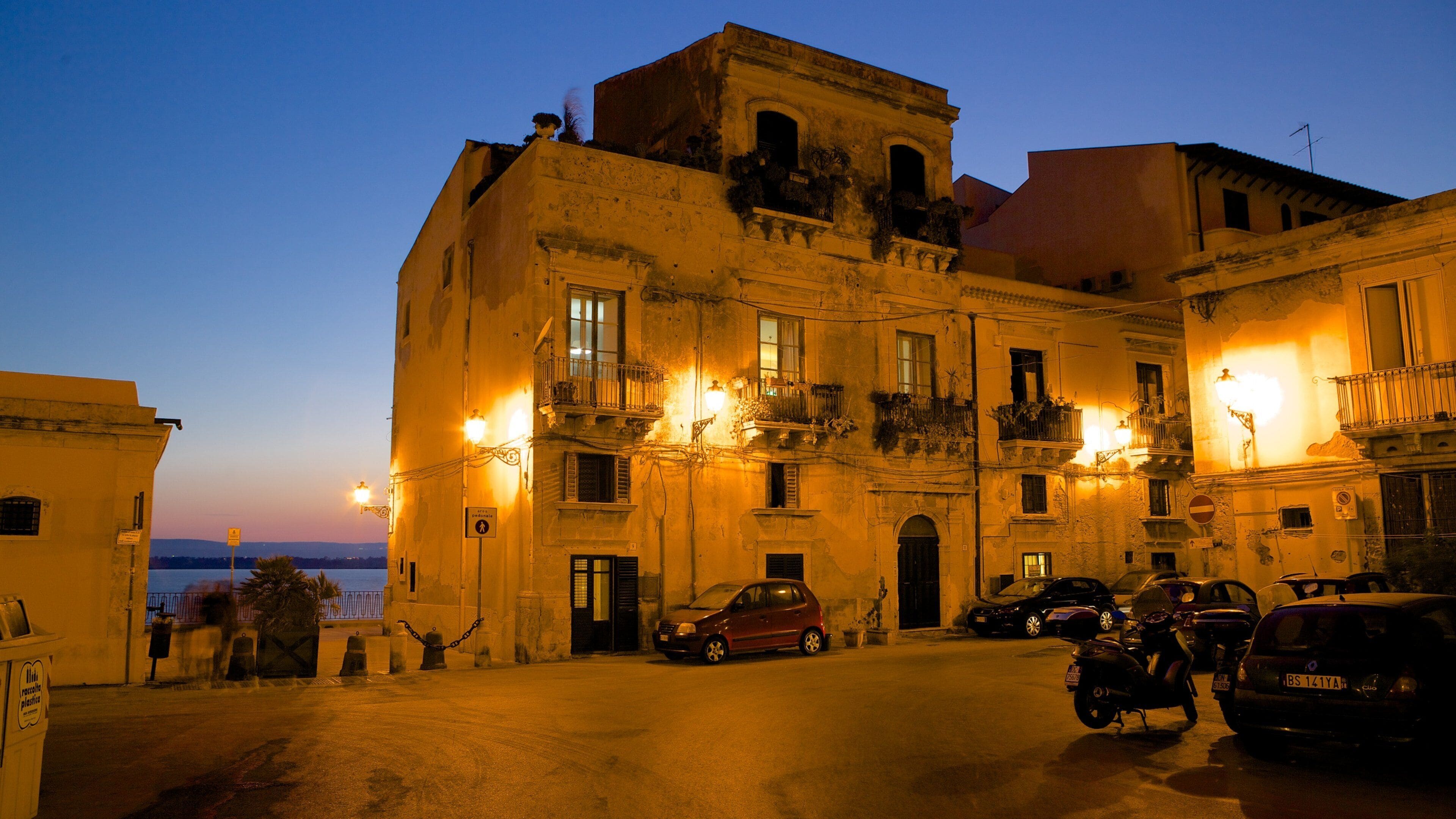 Ortygia que incluye una ciudad costera, escenas urbanas y una puesta de sol