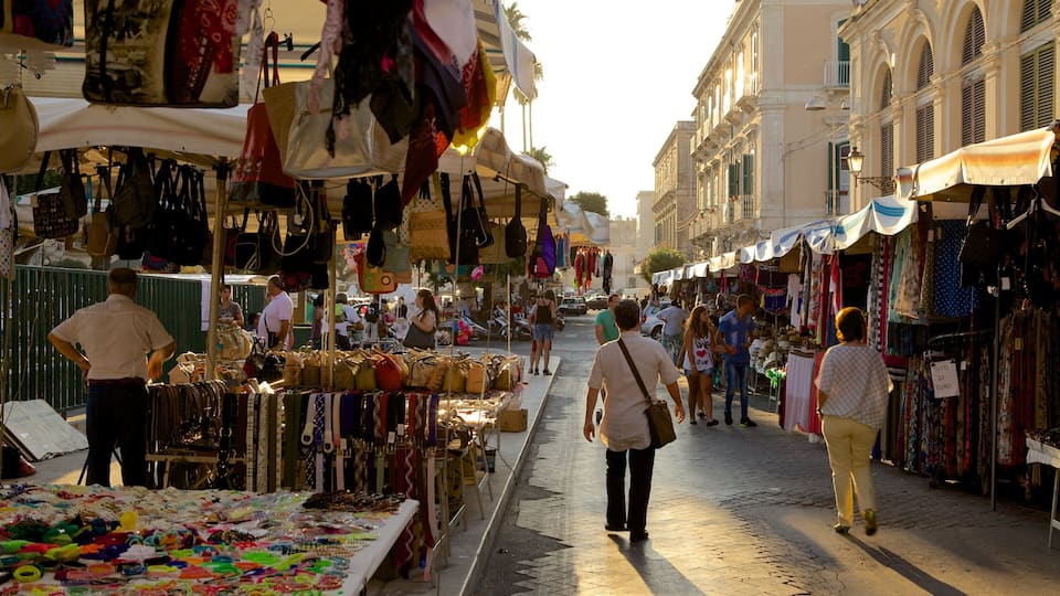 A bustling outdoor market with various stalls selling bags, textiles, and jewelry.