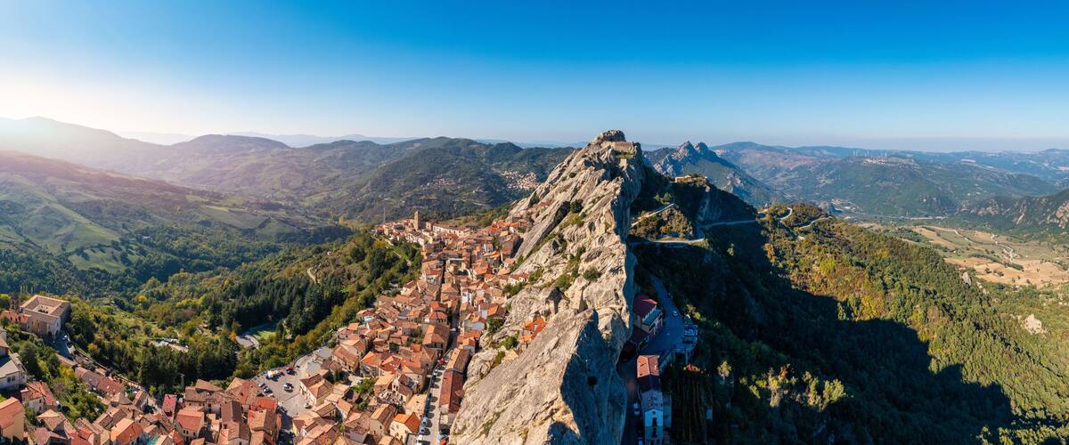 A town perched on a mountain ridge with a historic castle on top.