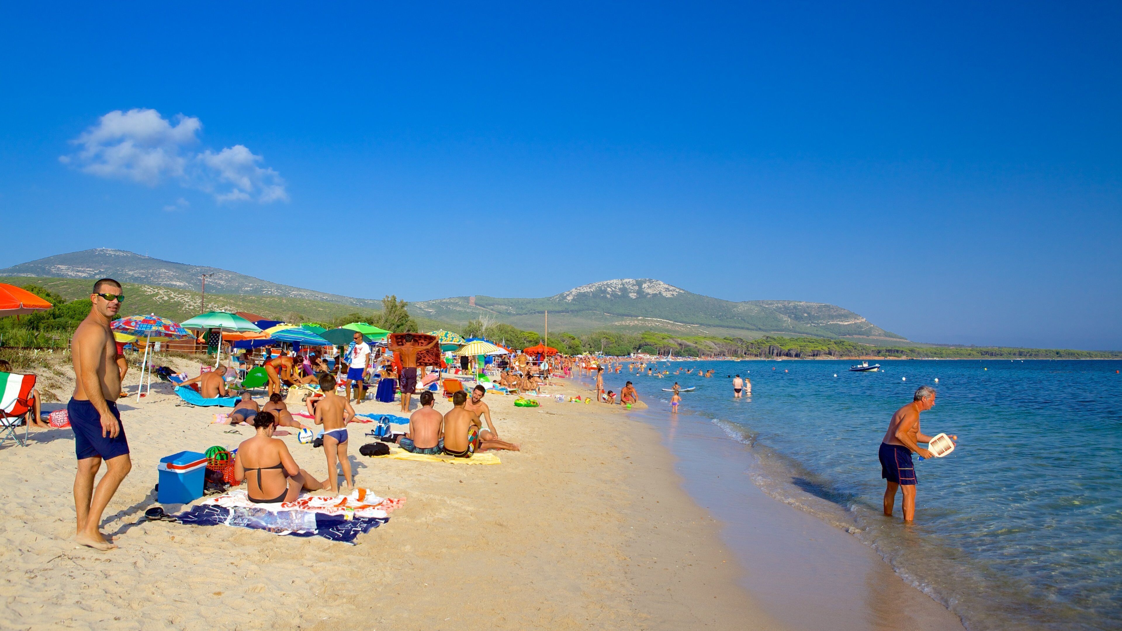 Playa de Mugoni ofreciendo una playa de arena y también un gran grupo de personas