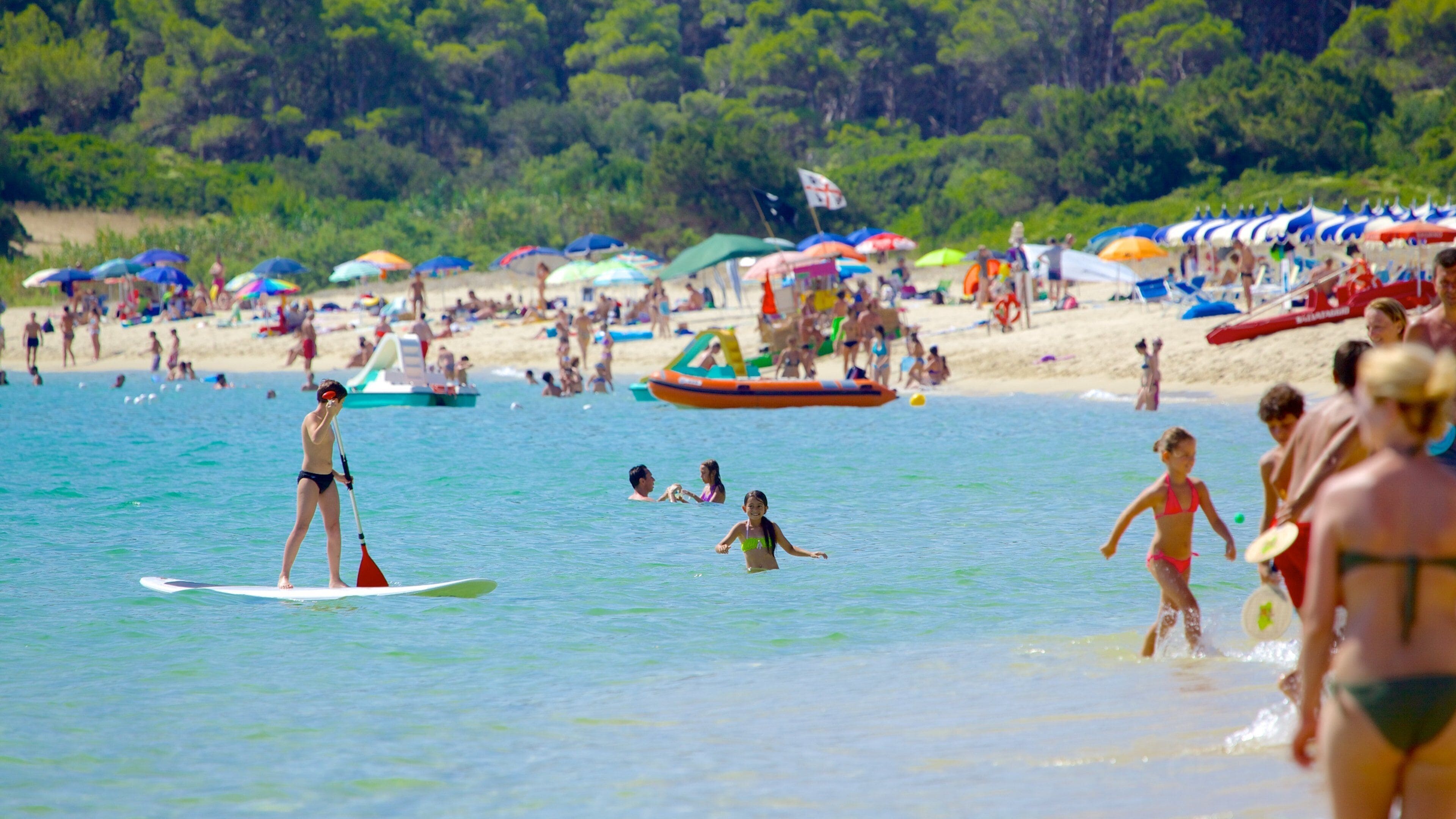 Cala Sinzias-strand toont een zandstrand, watersport en zwemmen