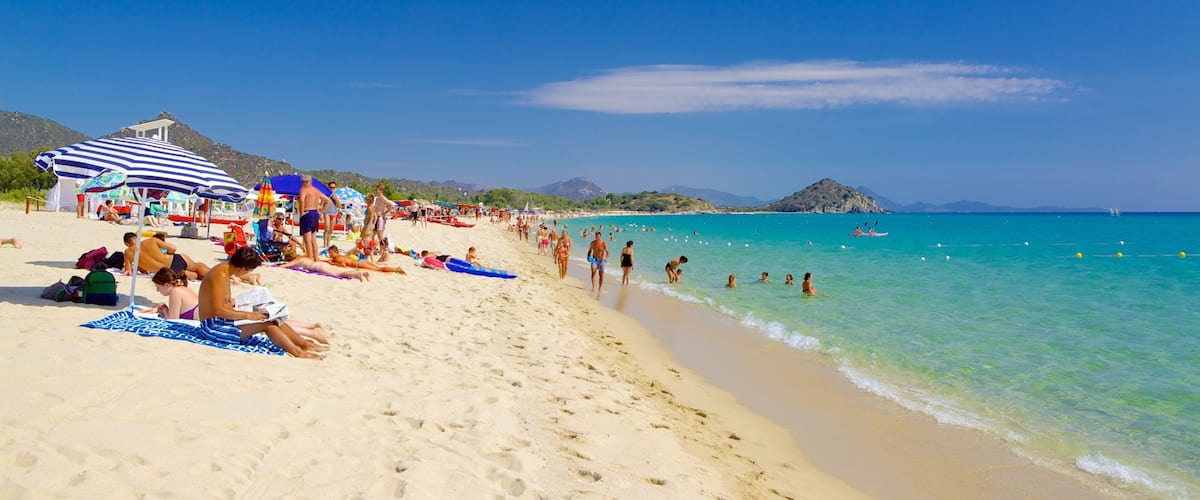 A crowded beach with people sunbathing and swimming.