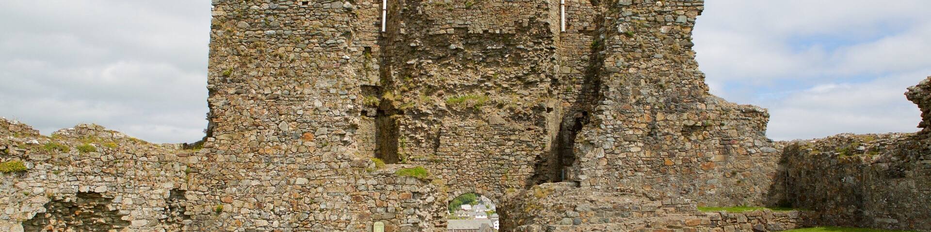 A stone castle ruin with two flags flying atop.