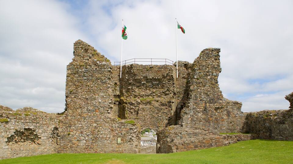 A stone castle ruin with two flags flying atop.