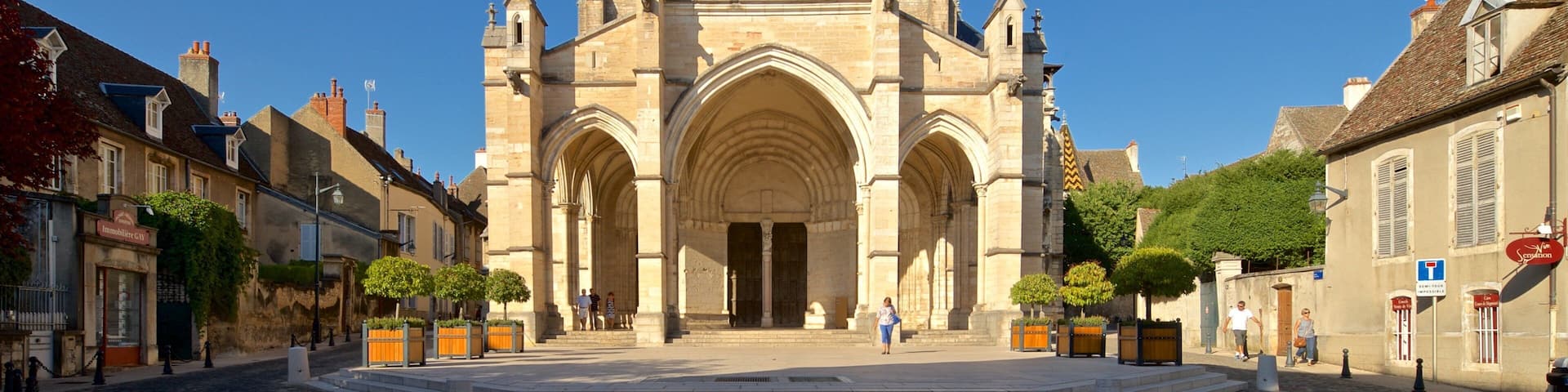 A historic cathedral with three large arches and a central tower.
