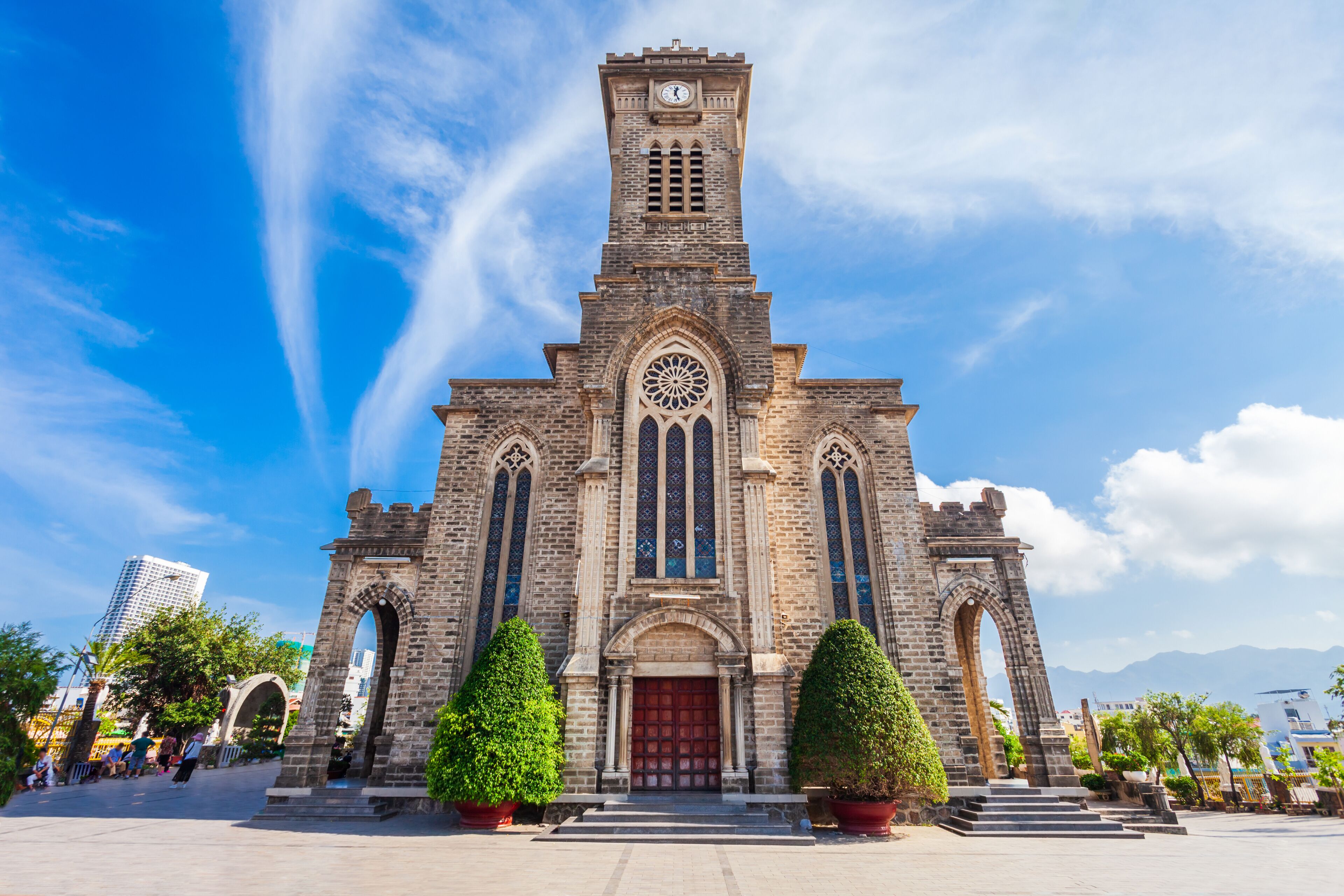 A historic church with a clock tower, arched windows, and a red door.