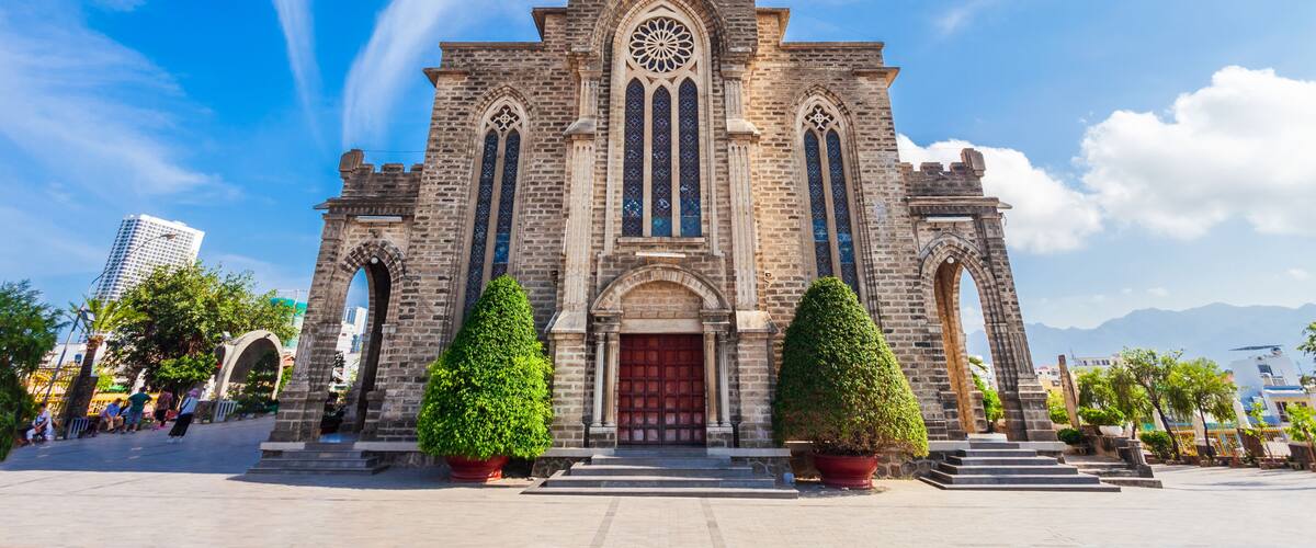 A historic church with a clock tower, arched windows, and a red door.