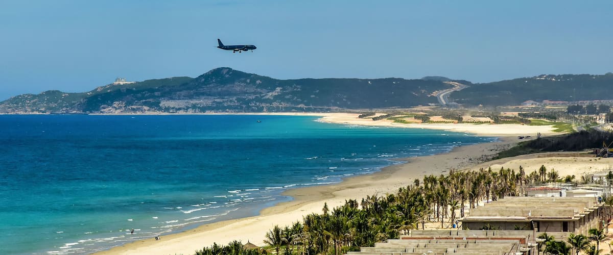 Cam Rahn. Vietnam. The plane flies over the road and the beach and landing at the airport