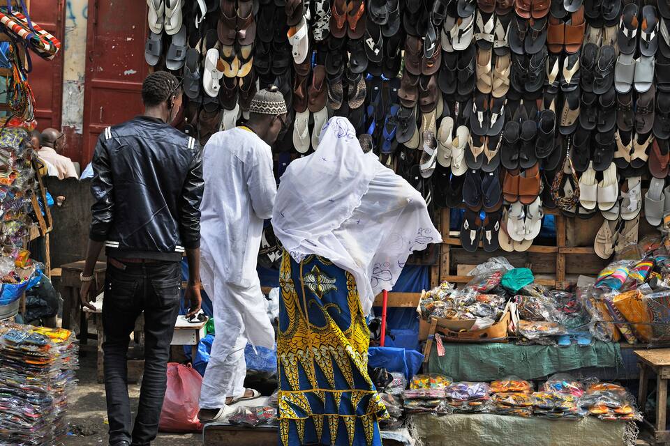 Un mercato con una vasta esposizione di scarpe e tessuti.