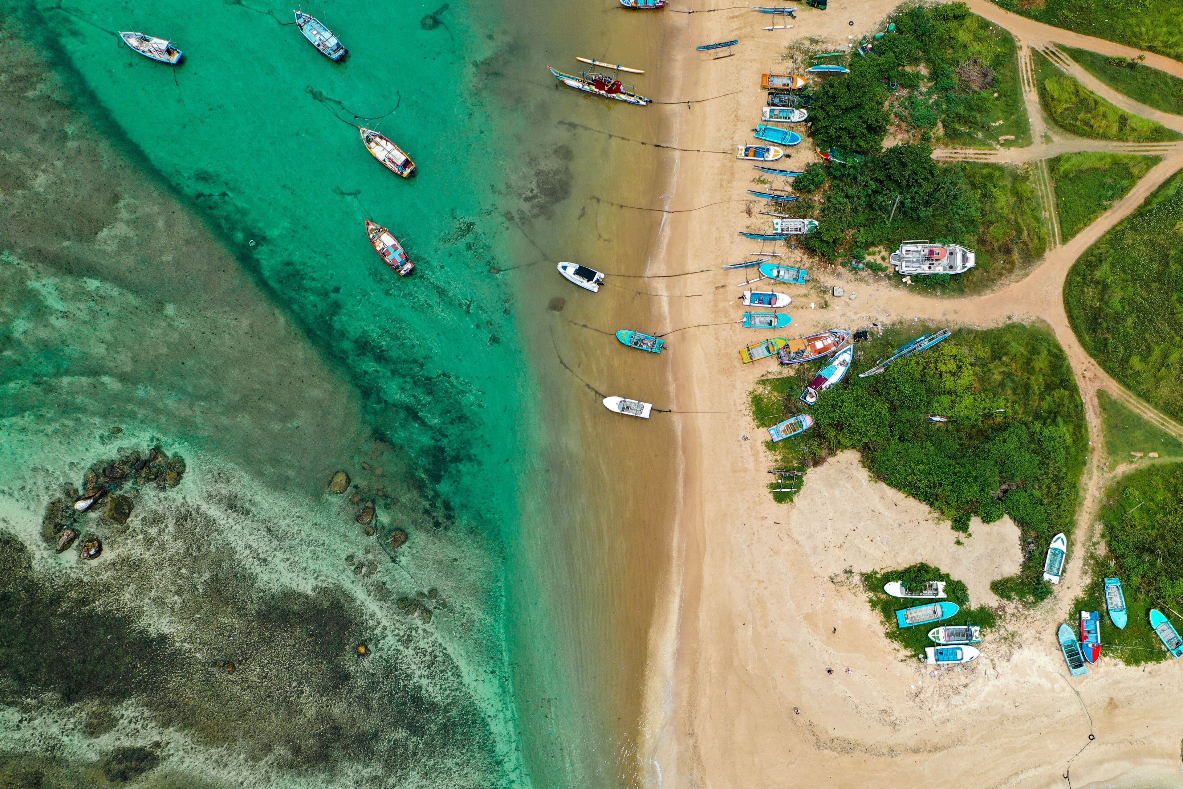 Sri Lankan coastal life captured from above—Weligama Beach with traditional boats, palm forest, and serene ocean vibes.