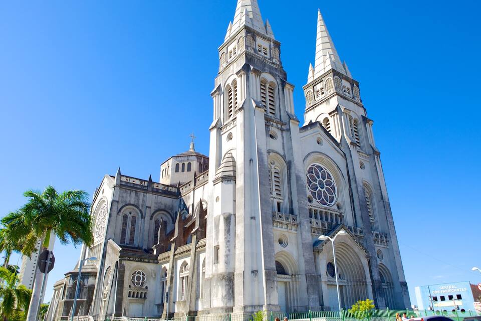 Uma grande catedral com duas torres altas e um vitral rosáceo.