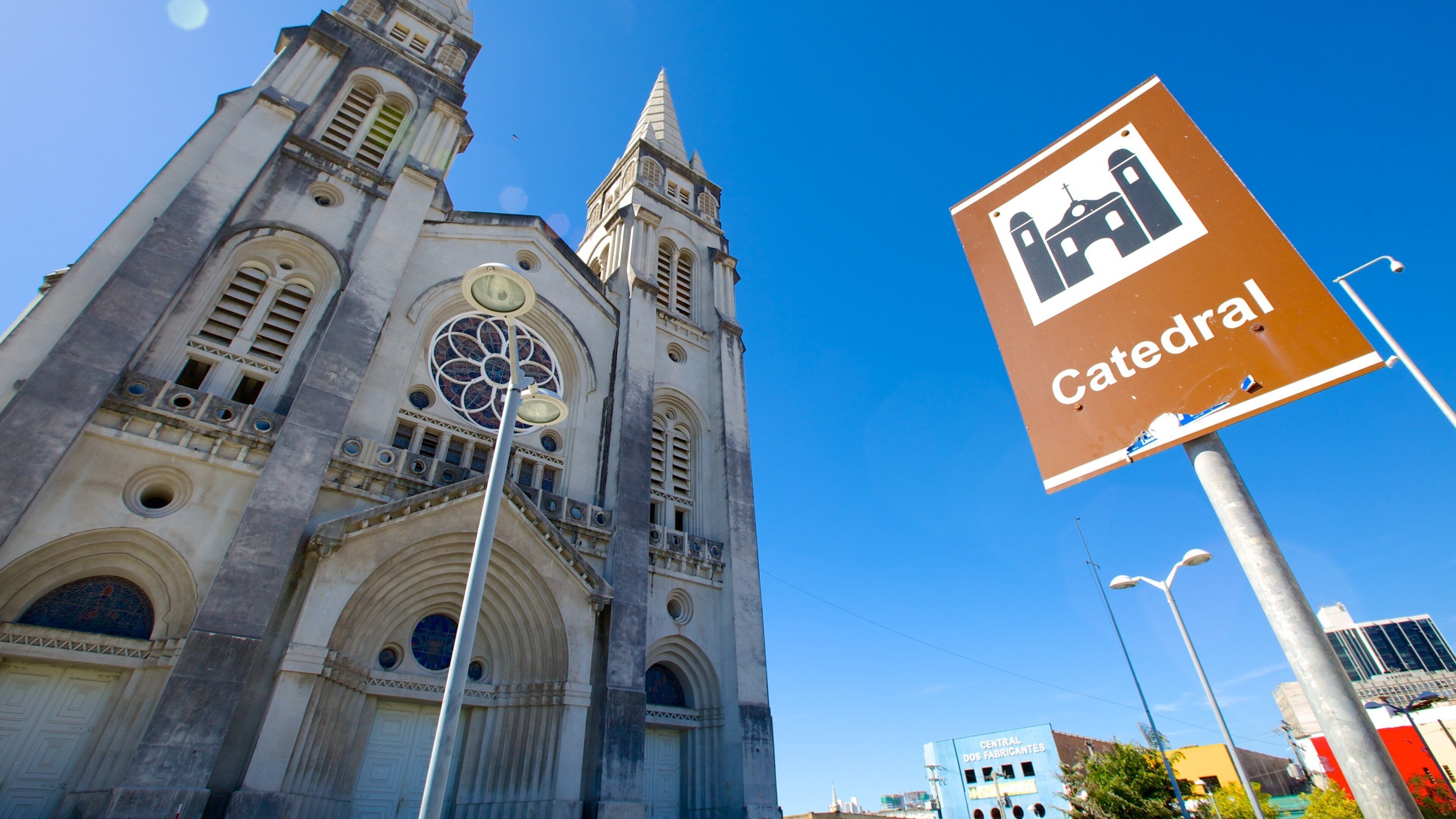 A cathedral with a tall spire and a large circular stained glass window.
