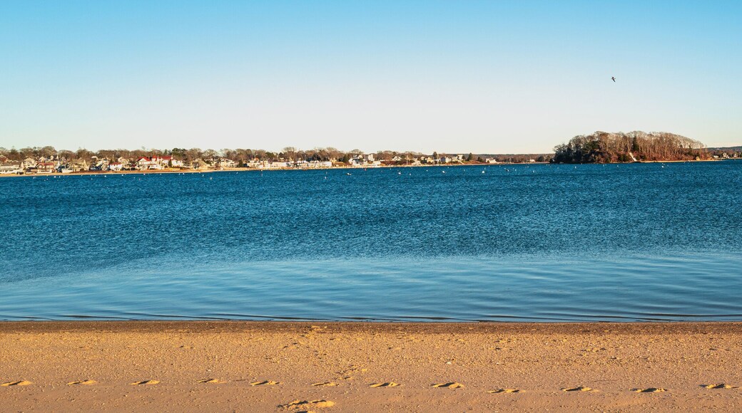 Topographical beach and ocean landscape with footprints on the sand. Tranquil sun down seascape over the Onset Bay and Beach in Onset, Massachusetts during the off-season.