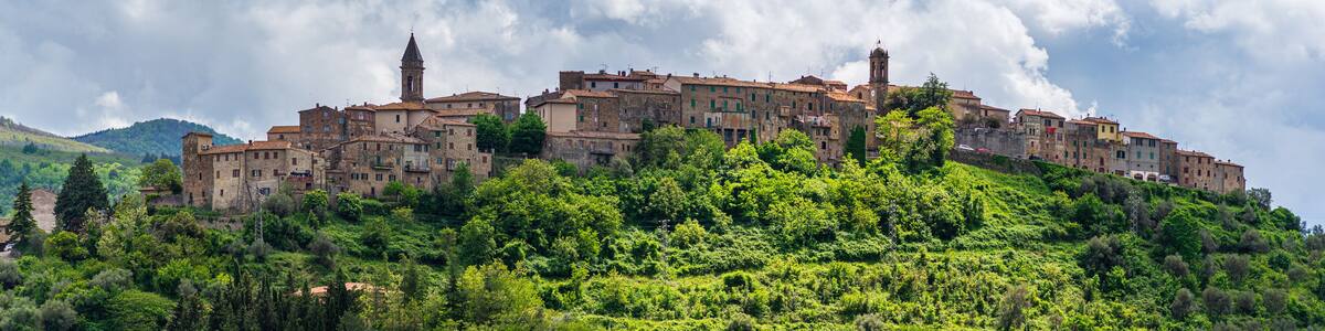 Seggiano, a medieval village and fortress in Monte Amiata region, Tuscany, Italy. The stone buildings perched on hill top and rock cliff against dramatic sky.