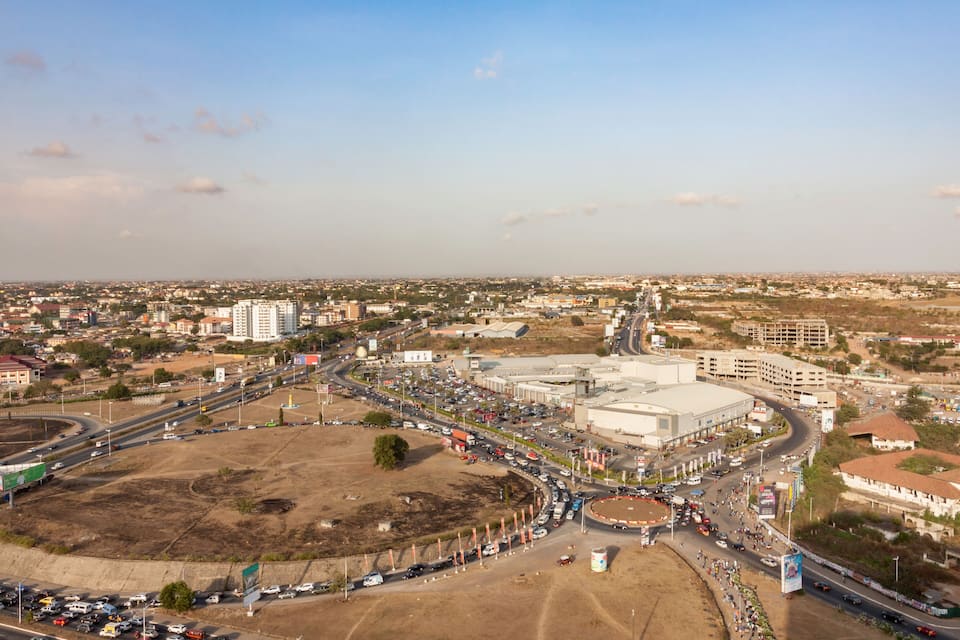 A cityscape with a large industrial area, a roundabout, and surrounding residential and commercial buildings.