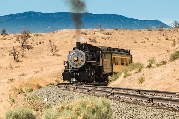 Steam trail driving though Nevada desert. Virgina & Truckee Railroad