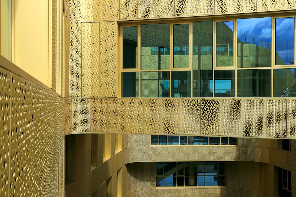 A modern building with a textured facade and multiple windows.