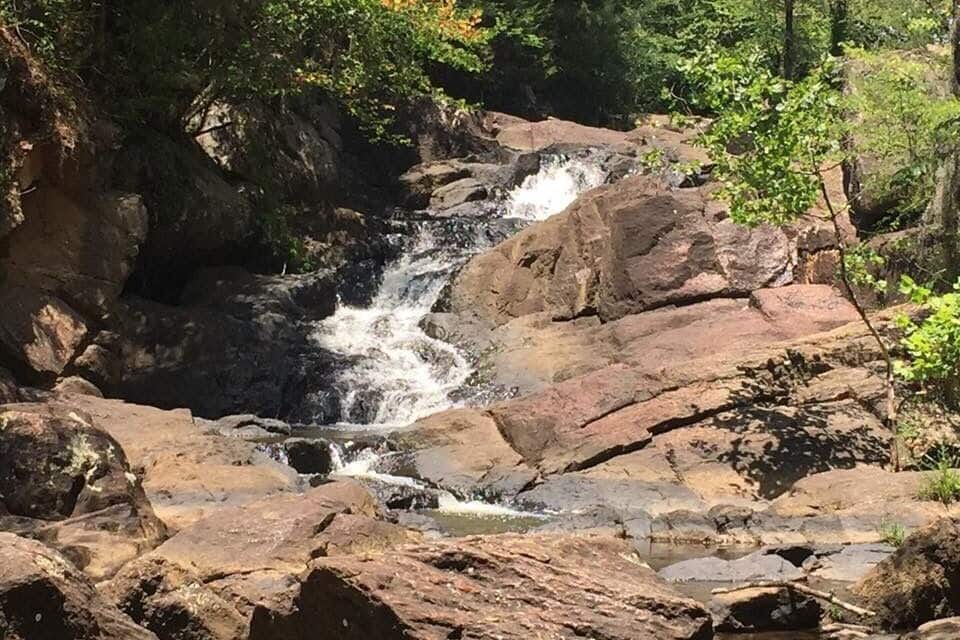 A waterfall cascading over rocks in a forested area.