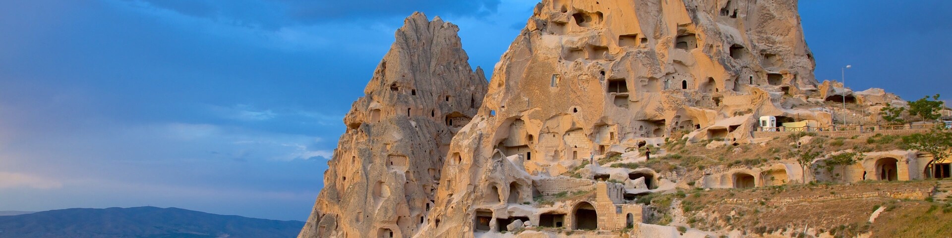 A rugged mountain with numerous cave dwellings carved into the rock.