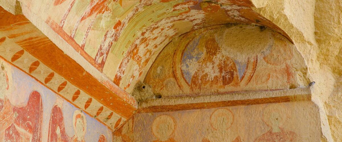 A fresco with geometric patterns and figures, possibly depicting a historical scene.