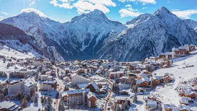 A snow-covered mountain town with buildings and ski slopes.