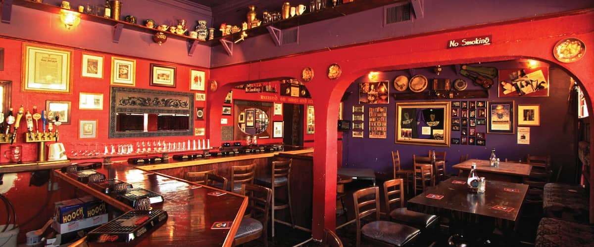 A bar with wooden furniture, a red wall, and various decorations.