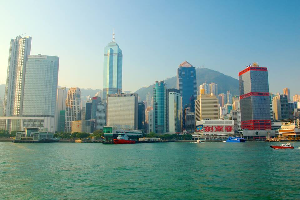 A city skyline with high-rise buildings and a body of water in the foreground.