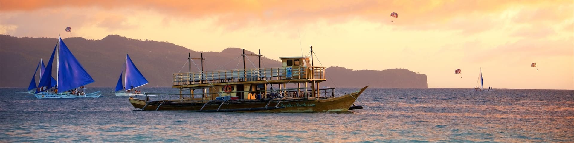 Aklan som inkluderar kustutsikter, en solnedgÄng och segling