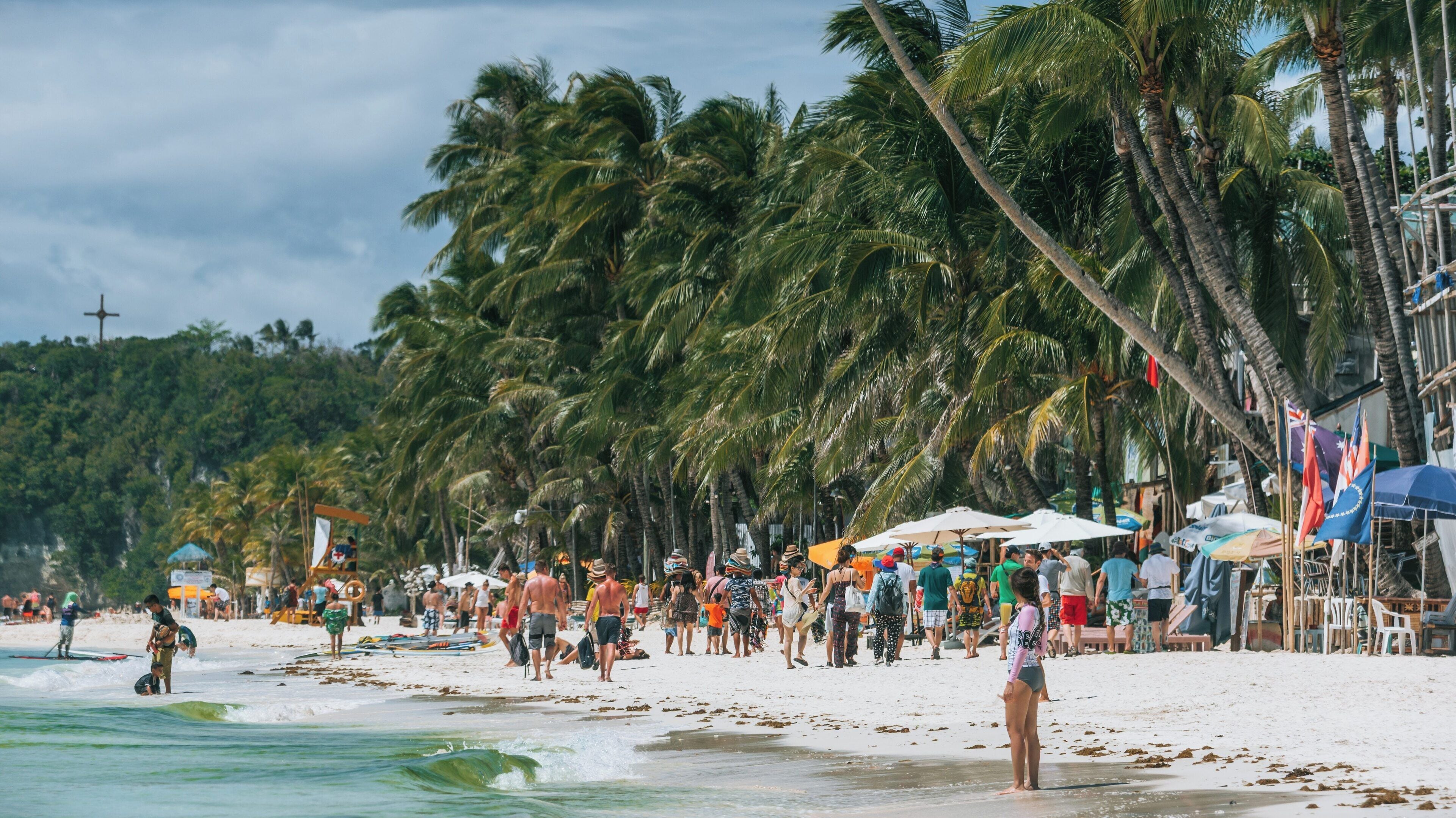 Beautiful White Beach on Boracay Island in the Philippines with palm trees and visitors enjoying the sunny day